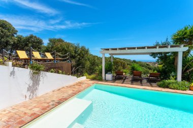 Havuzun yanındaki bahçede çam ormanı manzaralı bir çardak turistlerin dinlenebileceği bir yer. Güneş yatakları güneşlenmek içindir..