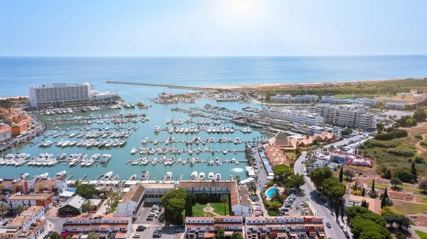 Ein Blick vom Himmel auf die portugiesische Touristenstadt Vilamoura, mit Yachten und Segelbooten, die im Hafen auf dem Dock festgemacht haben. — Stockfoto