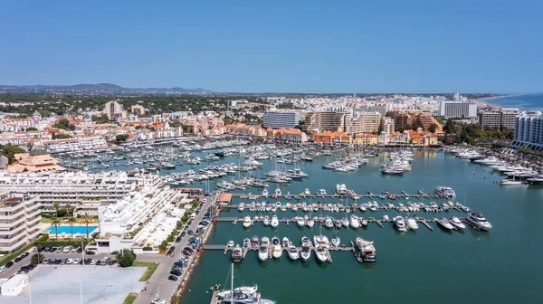 Ein Blick vom Himmel auf die portugiesische Touristenstadt Vilamoura, mit Yachten und Segelbooten, die im Hafen auf dem Dock festgemacht haben. — Stockfoto