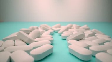İlaç endüstrisinin bir konsepti olarak mavi arka planda, beyaz hapların aşırı yakın çekimi.
