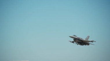 F-16 askeri Amerikan jet uçağı taktik eğitim uçuşu için kalkıyor. Süper sonik motorlardan yangın çıkışları.