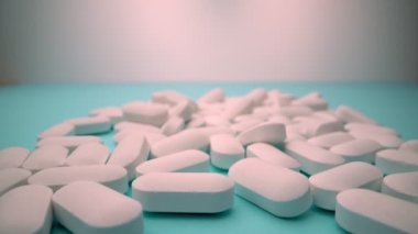 İlaç endüstrisinin bir konsepti olarak mavi arka planda, beyaz hapların aşırı yakın çekimi.