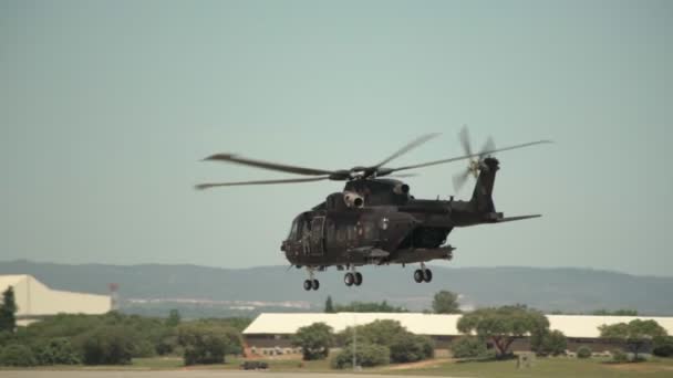 Um helicóptero militar americano voa em câmera lenta, perto, em exercícios militares, sobre a base das forças armadas. — Vídeo de Stock