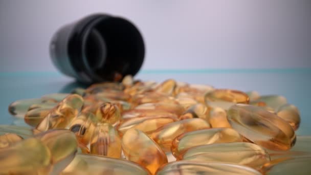 Extreme macro in beweging, gele omega capsules voor het aanvullen van vetten en vitaminen in voeding en dieetvoeding. Concept, copuruimte. — Stockvideo