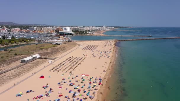 Flygvideo, vackra portugisiska stränder, nära turiststaden Vilamoura, Falesia, med utsikt över hamnen. Turister solbadar. — Stockvideo