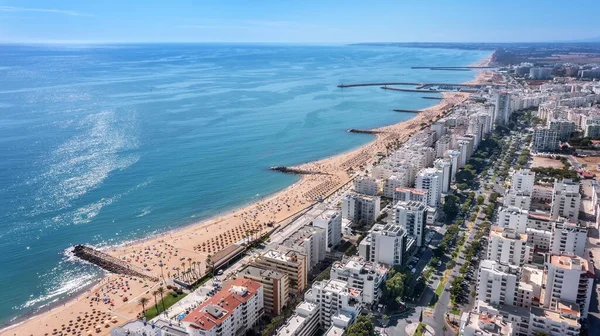 Piękne lotnicze krajobrazy turystycznego portugalskiego miasta Quarteira. Na wybrzeżu w sezonie plażowym z turystami opalającymi się. — Zdjęcie stockowe