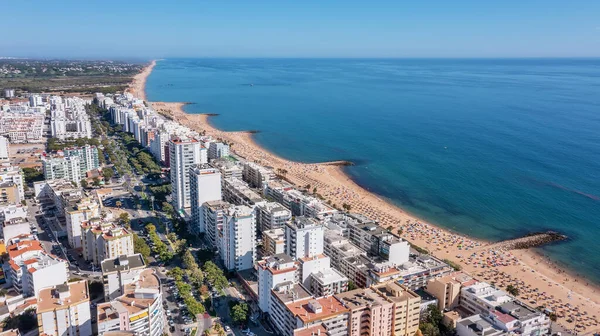 Schöne Luftaufnahmen der touristischen portugiesischen Stadt Quarteira. An der Küste während der Badesaison mit Touristen, die sich sonnen. — Stockfoto