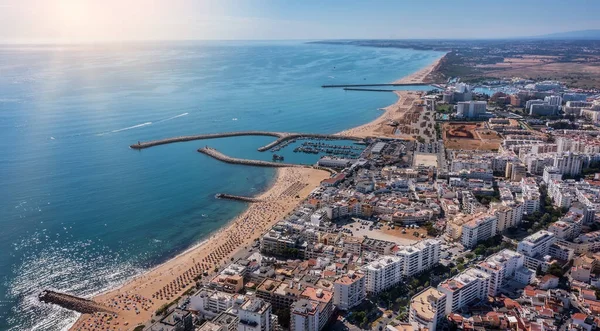 Krásné letecké městyscenérie turistického portugalského města Quarteira. Na pobřeží během plážové sezóny s turisty, kteří se opalují. — Stock fotografie