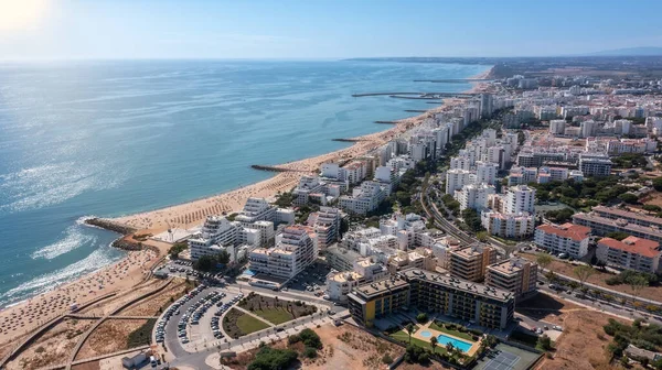 Hermosos paisajes aéreos de la ciudad turística portuguesa de Quarteira. En la orilla del mar durante la temporada de playa con turistas que están tomando el sol. — Foto de Stock