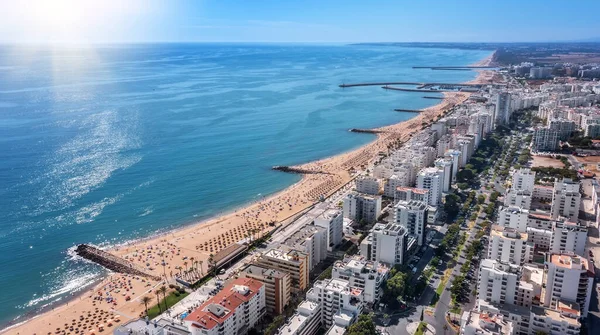 Piękne lotnicze krajobrazy turystycznego portugalskiego miasta Quarteira. Na wybrzeżu w sezonie plażowym z turystami opalającymi się. — Zdjęcie stockowe