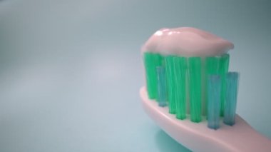 Ekstrem makro video çekimi, mavi arka planda diş fırçası, fırçada diş macunu. İleri hareket, yakın çekim.
