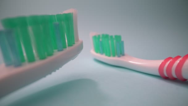 Filmagem de vídeo macro extrema, escova de dentes em um fundo azul em movimento, movimento para a frente. Close-up. — Vídeo de Stock