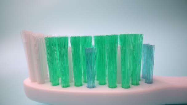 Filmagem de vídeo macro extrema, escova de dentes em um fundo azul em movimento, Aplicando pasta de dentes para a escova.. Close-up. — Vídeo de Stock