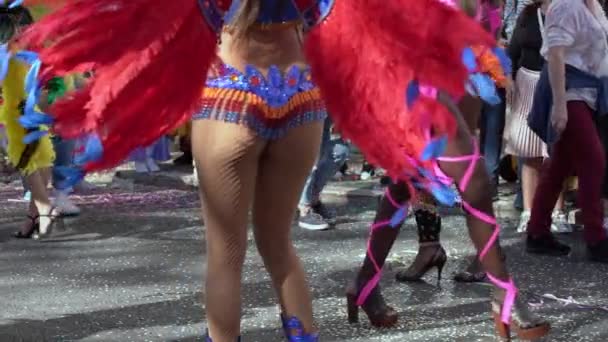 Традиційне святкування веселощів і танців карнавалу, жінки, які беруть участь у карнавальній прогулянці вулицями, одягнені в різнокольорові костюми. Крупним планом. Повільний рух . — стокове відео