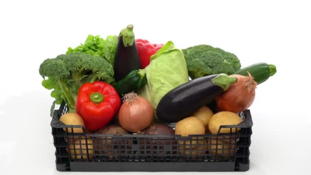 Szállítódoboz válogatott friss bio zöldségekkel, eladásra vagy jótékonyságra készen. Mozgásban előre mozgás fehér háttérrel, közelkép. — Stock videók