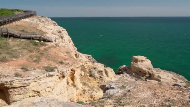 Yazın, Portekiz 'in Carvoeiro sahilinin ahşap patikalar boyunca yürüdüğü harika bir manzara. Mavi deniz manzaralı. Dengeleyiciyle atış.. — Stok video