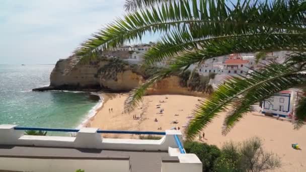 Bela vista da praia portuguesa do Carvoeiro, no verão, com mar límpido e banhos de sol. Tiro em movimento com um estabilizador. — Vídeo de Stock