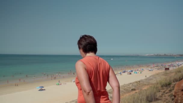 레어 뷰, 중년, 비만인 여성, 체조 연습중이거나 몸을 따뜻하게 하는 동안 말이죠. 해변에서 해변을 볼 수있었습니다. 느린 동작 — 비디오