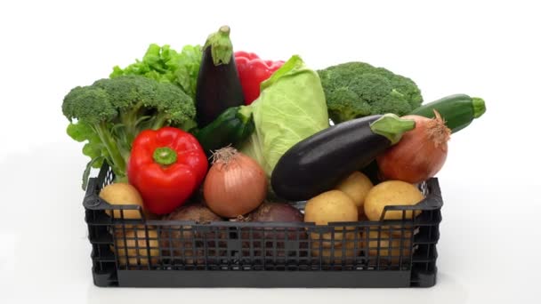 Caja de entrega con una variedad de verduras orgánicas frescas, listas para la venta o caridad. En movimiento hacia adelante sobre un fondo blanco, primer plano. — Vídeo de stock