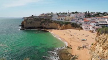 Portekiz Carvoeiro sahilinin açık deniz ve güneşlenen turistlerle dolu güzel bir manzarası var. Dengeleyiciyle atış..
