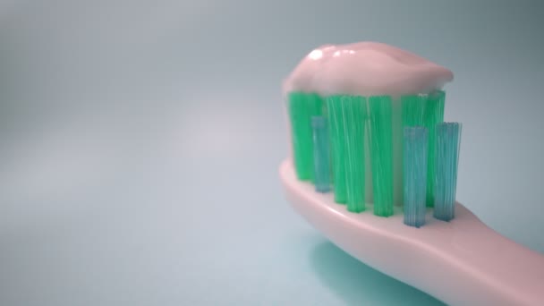 Filmagem de vídeo macro extrema, escova de dentes em um fundo azul em movimento, pasta de dentes na escova. Movimento para a frente, close-up. — Vídeo de Stock