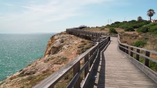 Maravilhosa vista da costa portuguesa do Carvoeiro no verão, caminhando pelos caminhos de madeira. Com vista para o mar azul. Tiro em movimento com um estabilizador. — Vídeo de Stock