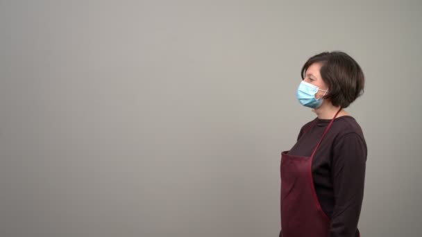 A volunteer distributor, handing a box to a masked woman with fresh vegetables for those in need. In times of crisis or pandemic, the poor. — Stock Video