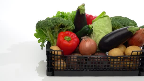 Caja de entrega con una variedad de verduras orgánicas frescas, listas para la venta o caridad. En movimiento lateral movimiento sobre un fondo blanco, primer plano. — Vídeos de Stock