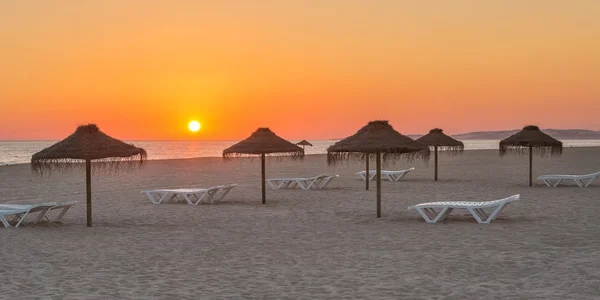 Magische zonsondergang op het strand. Met de ligstoelen en parasols voor een ontspannen. — Stockfoto