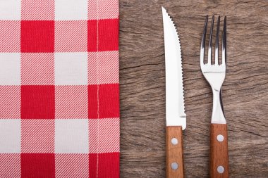 Dekoratif peçete, bıçak ve çatal. Ahşap dokusu üzerinde.
