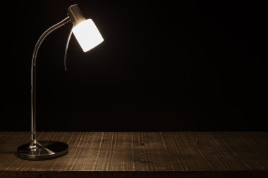 Lamba gölge masanın üzerinde. Karanlık bir arka plan.