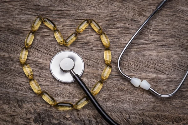 Estetoscópio médico na vitamina e. Na forma de um coração. — Fotografia de Stock