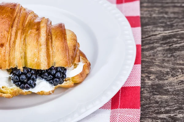 Delicioso croissant con nata y arándanos. Para el desayuno. —  Fotos de Stock