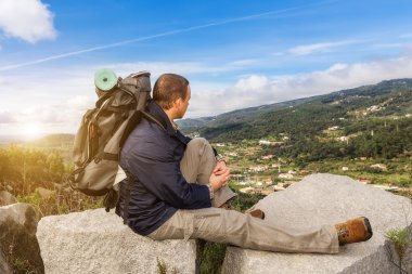 Hiking günbatımında bir sırt çantası ile adam. Manzarası ile dağlarda.