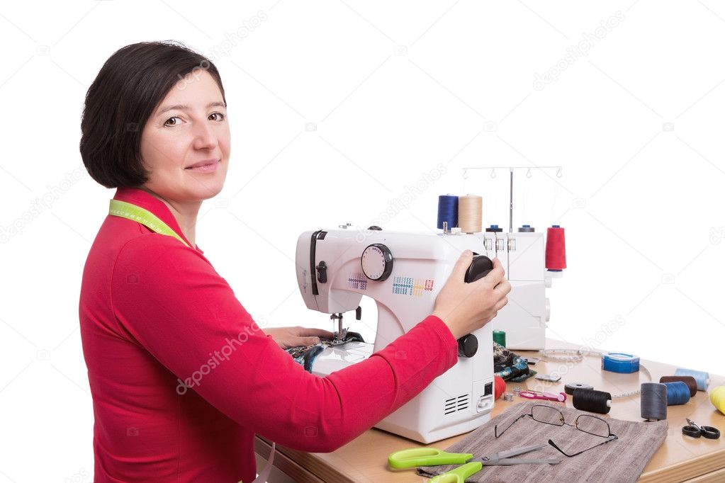 Woman seamstress at the sewing machine. Sews clothes.