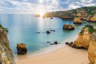 Deniz plaj gün batımında. Bulutlu gökyüzü. Portekiz, Algarve, Lagos.