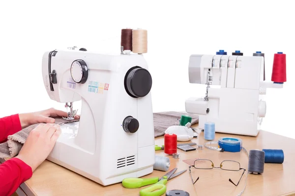 Vrouw naaister werk op de producten van de naaimachines. Op een witte achtergrond. — Stockfoto