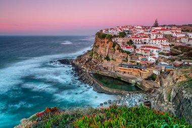 Günbatımı Azenhas do Mar şehirde. Doğal havuzu ile.