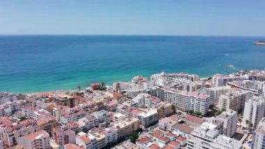 Kıyı insansız hava aracı fotoğrafçılığı, deniz kenarı deniz manzarası, turkuvaz suları ve yukarıdan sakin manzara, huzurlu sahil kasabası ve denizin nefes kesici hava görüntüsü.