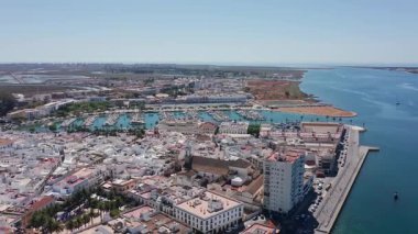 Ayamonte Havacılık 'ın insansız hava aracı görüntüsü liman silueti ve gök mavisi sahili yüksek liman binası, marina rıhtımı, haliçağzı ve dramatik kompozisyon için geniş açık ufuk..