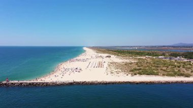 Tavira Portekiz 'in hava görüntüsü, geniş kumsal ve sahil manzaralı, yumuşak dalgalı ve dağınık güneşli hava manzaralı, serbest yüzen fotoğrafçılar kum tepelerini ve kıyı şeritlerini yakalıyor.