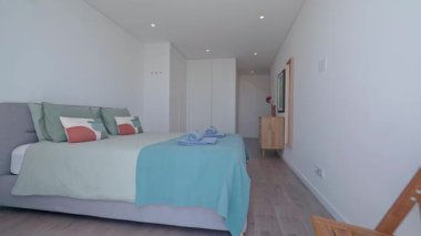 Doğal ışık modern bir otel odasını aydınlatıyor, minimalist dekorasyonlar, yumuşak yastıklı rahat bir yatak ve sarılıp sarmalanmış havlular, rahatlatıcı ve davetkar bir atmosfer yaratıyor.