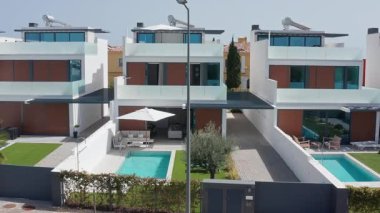 Özel yüzme havuzları, bahçeleri ve modern mimari stantları olan özdeş evler üst üste dizilerek, bir üniforma ve çekici bir mahalle yaratıyorlar.