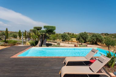 Güneş pansiyonları rahatlamaya açık bir havuzun yanına davet eder. Zeytin ağaçları huzurlu manzarada gölge sağlar. Yazın açık havada dinlenmek için birebirdir..