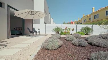 Ağaç kabuğu, lavanta çalıları ve veranda şemsiyesi rahat ve keyif almak için huzurlu bir ortam yaratıyor.