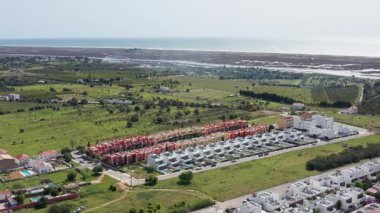 Üniformalı yerleşim yerleri kıyı manzarası boyunca yayılıyor, sistematik kentsel gelişimi ve okyanus manzarası yakınlarındaki geniş banliyö büyümesini ortaya koyuyor. Tavira, Portekiz Fuzeta.