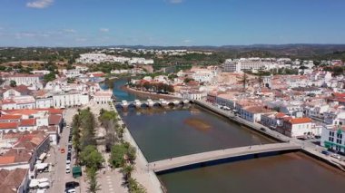 Hava sahası tavira portugal düşük gelgit kahverengi kanal ve köprüyü gösteriyor, çevre bilimci perspektifi çökelti desenlerini, nehir kenarlarını, tekneleri ve kentsel kenarları belgeliyor