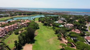 Vale de Lobo havacılık lagünü adası sarmal su kanalları, palmiye ağaçları ve tatil pazarlama ve kıyı hayat hikayeleri için yakalanan tatil havuzları olan villaları yeşillendirir.