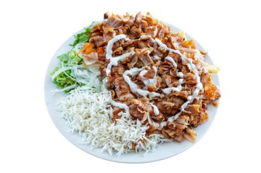 Taze et, taze yeşillik ve kremalı sos içeren nefis bir tavuk kebabı tabağı. İştah açıcı bir sunum için beyaz bir tabakta güzelce yerleştirilmiş.