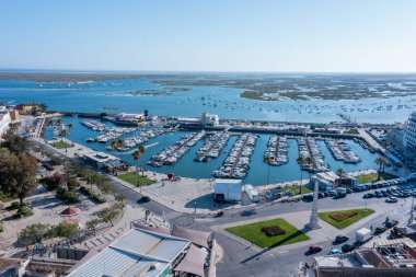 Ziyaretçiler Faro, Algarve rıhtımında yürüyüp, Portekiz 'de güneşli bir günde tekne ve Ria Formosa lagününün tadını çıkarıyorlar..